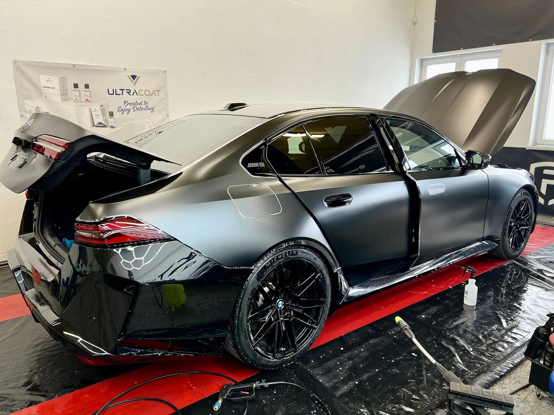 Oklejanie BMW M5 folią satynową w hali studia