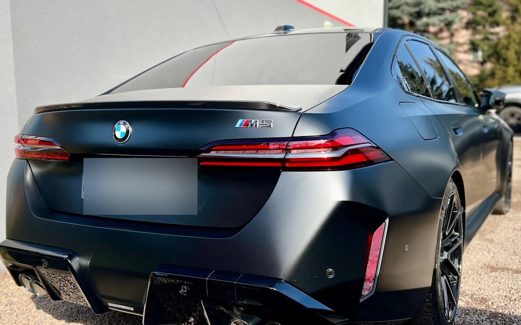 Tył BMW M5 po oklejeniu folią satynową — widoczny dyfuzor i poczwórna końcówka wydechu.