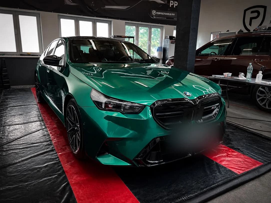 Przód BMW M5 w zielonej folii, w hali studia