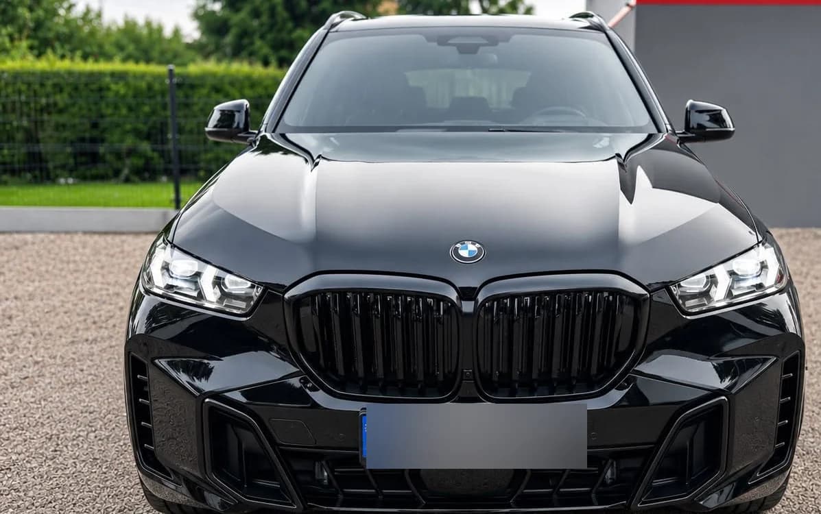Przód czarnego BMW X5 po zakończonej pracy — podświetlona atrapa i lakier bez widocznych krawędzi folii.