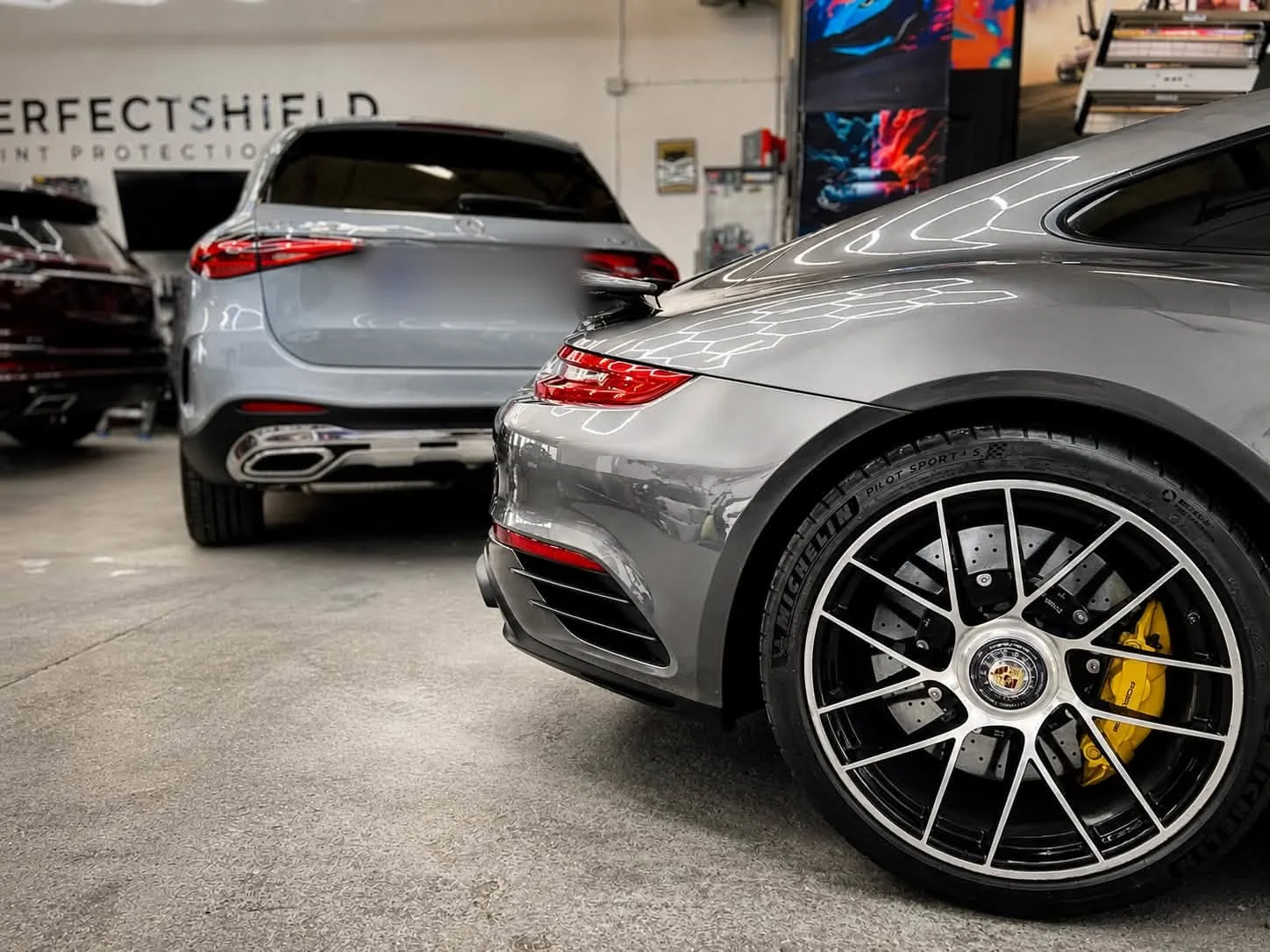 Tylne koło Porsche 911 Turbo S po detailingu — czysta felga i żółty zacisk hamulcowy z logo Porsche.