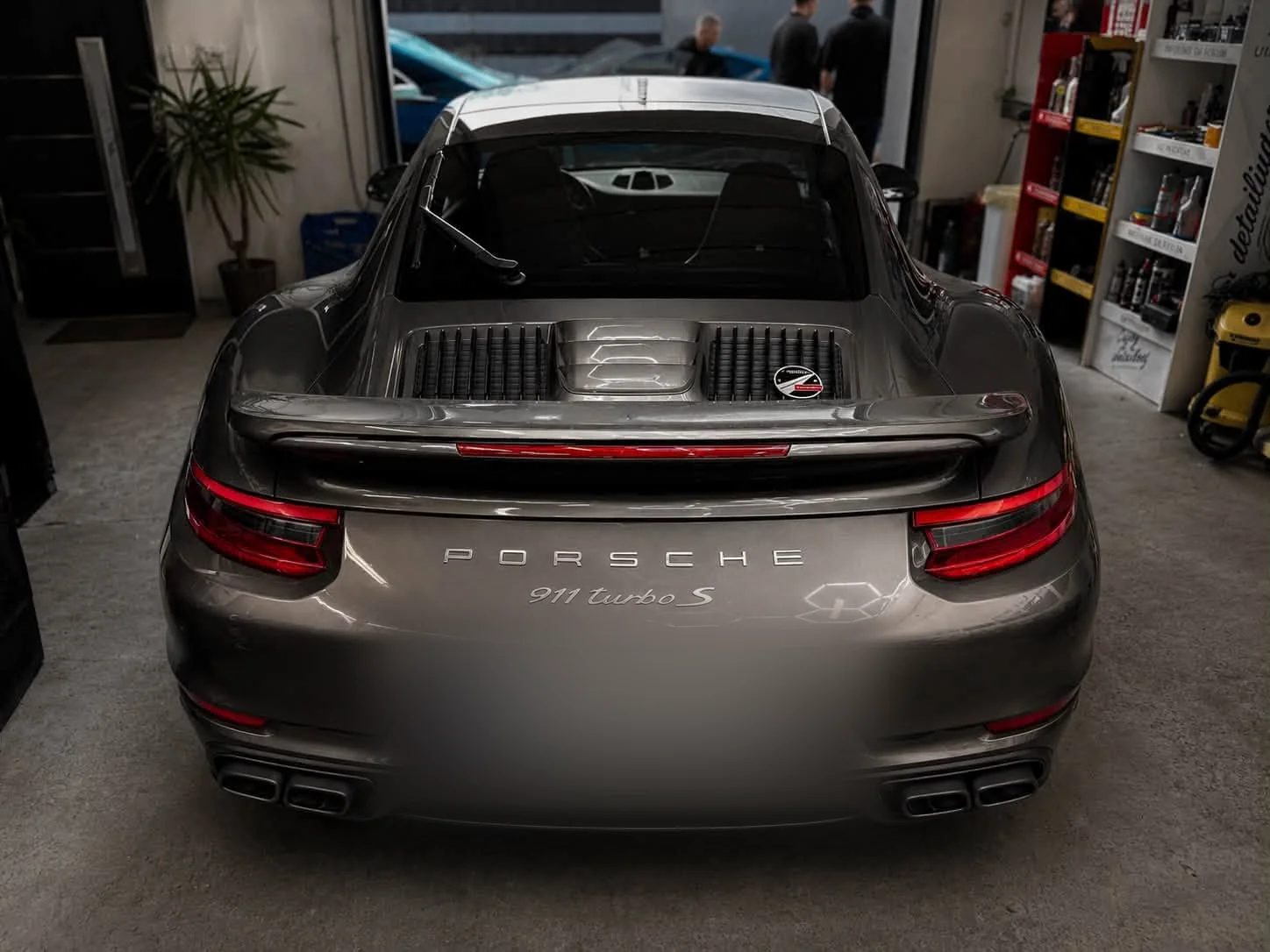 Tył srebrnego Porsche 911 Turbo S po pełnej pielęgnacji — widoczne tylne lampy, dyfuzor i napis 911 turbo S.