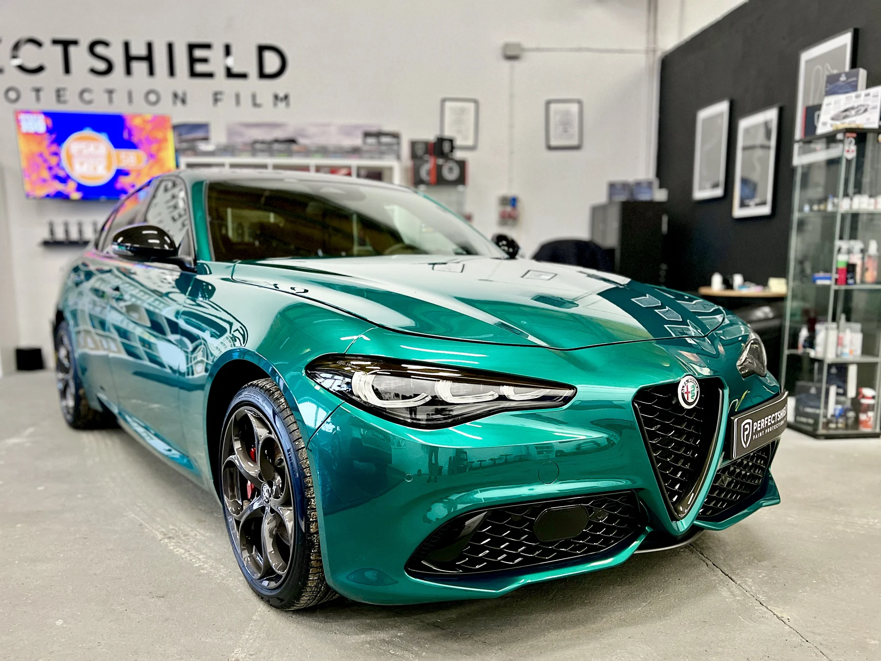 Alfa Romeo Giulia Quadrifoglio oklejona turkusową folią chromowaną — ujęcie z przodu w hali studia